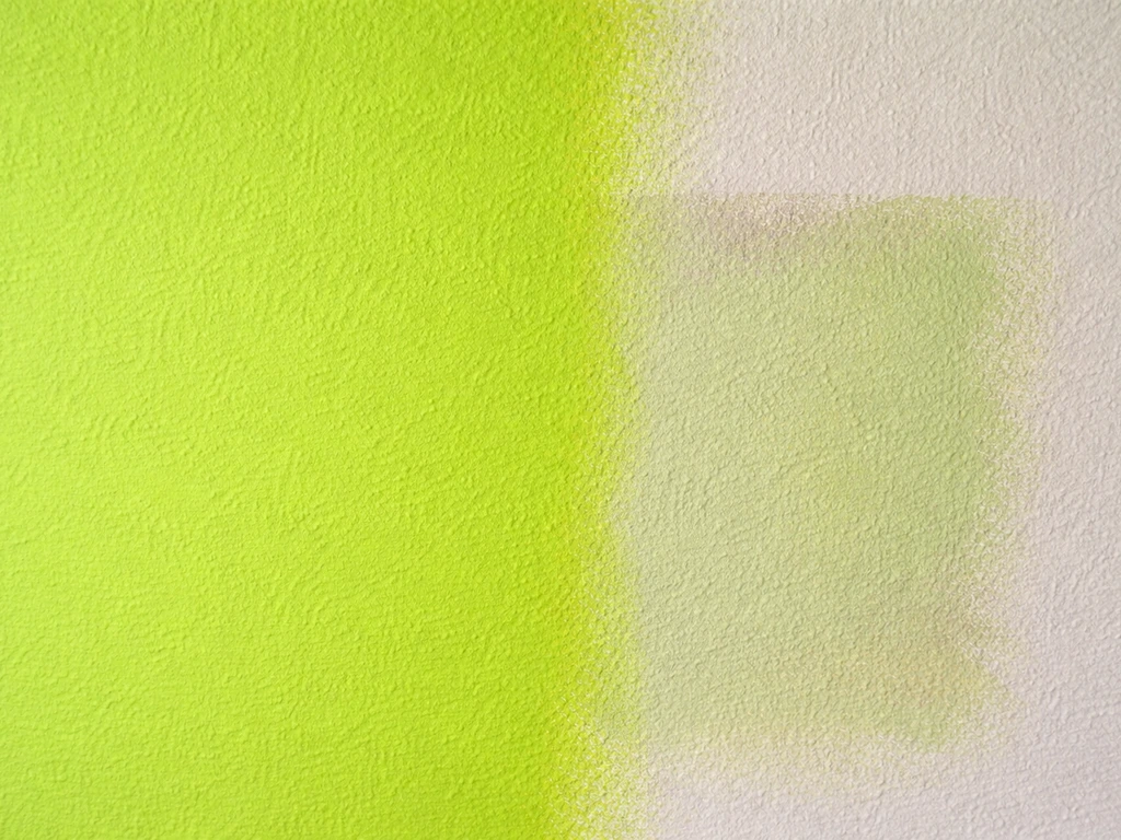 Mur peint vert trop fluo, puis échantillon corrigé avec un léger mélange violet/ocre, vue rapprochée